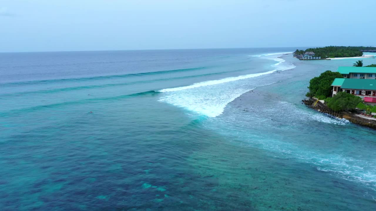 空中封锁拍摄的海浪飞溅向岛屿，而人们正在度假冲浪——马尔代夫的thulushoo视频素材