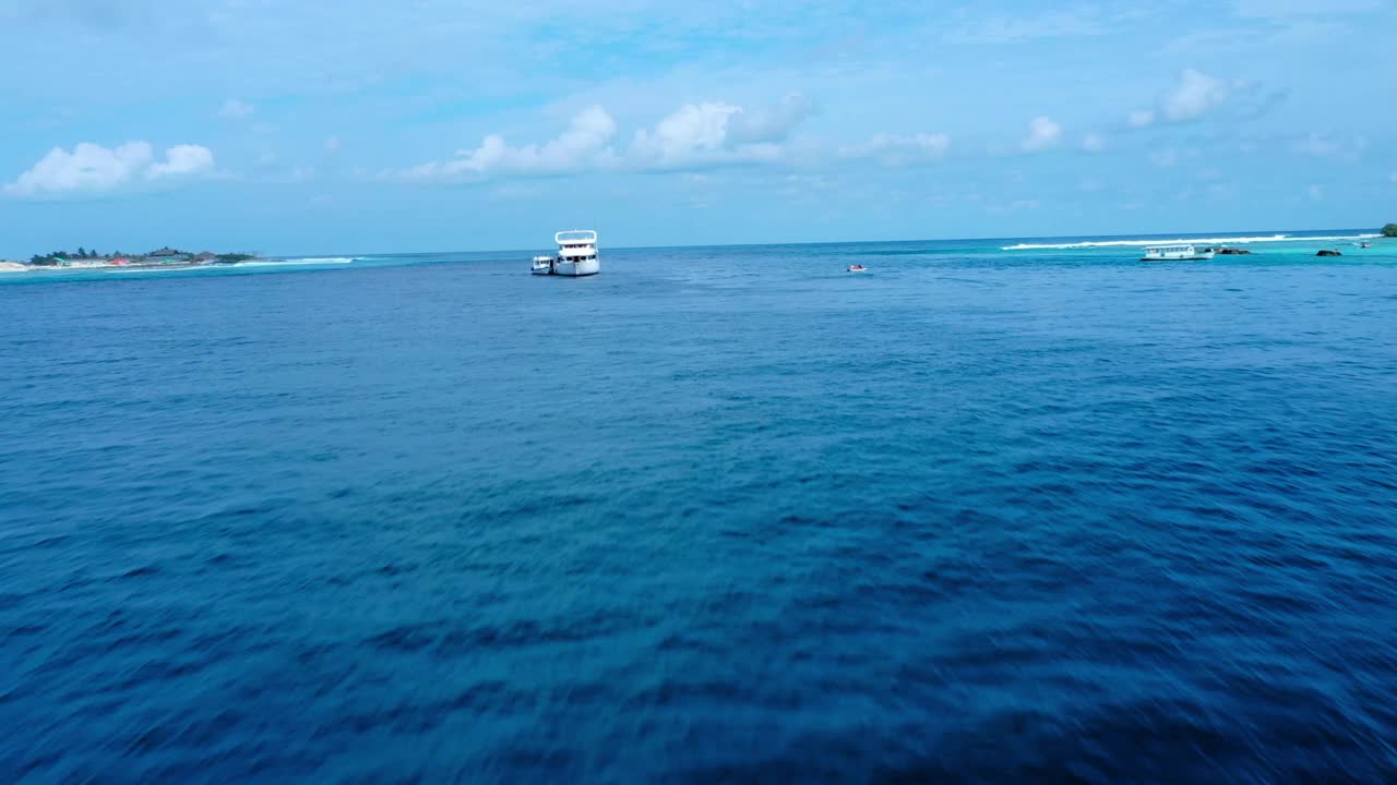 空中向前拍摄漂浮在海上的白色航海船只，无人机在晴天上升-马尔代夫的thulushoo视频素材