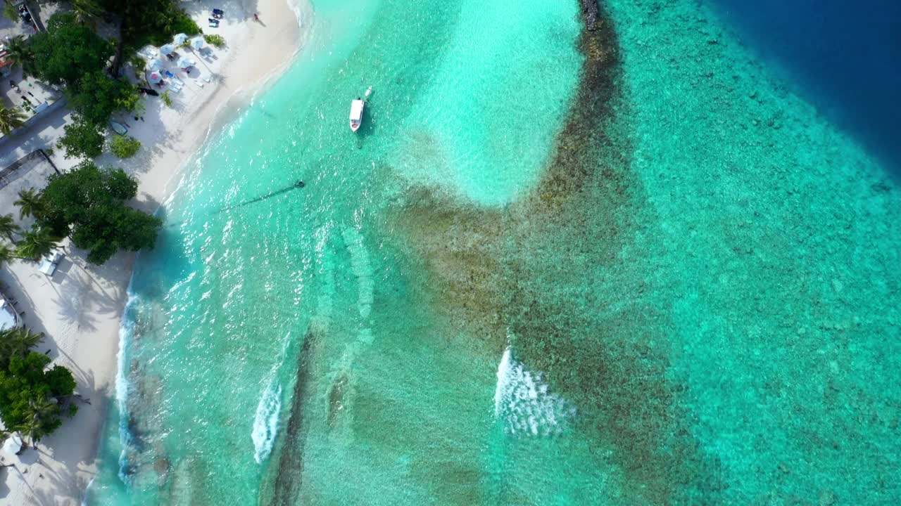 空中倾斜向上的观点，海上船只漂浮在岛屿在晴天- thulushoo，马尔代夫视频素材