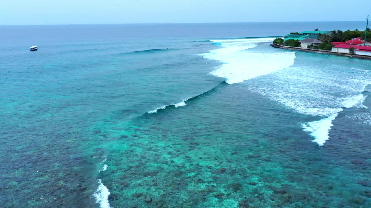 人们用冲浪板在岛上游泳的航拍，无人机在波浪般的海面上向前飞行-马尔代夫的thulushoo视频素材