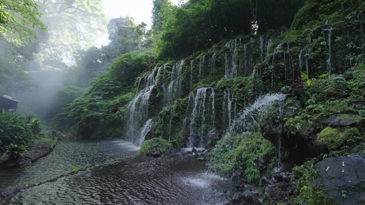 空中:美丽的水在森林岩石上流动的无人机视图-巴厘岛，印度尼西亚视频素材