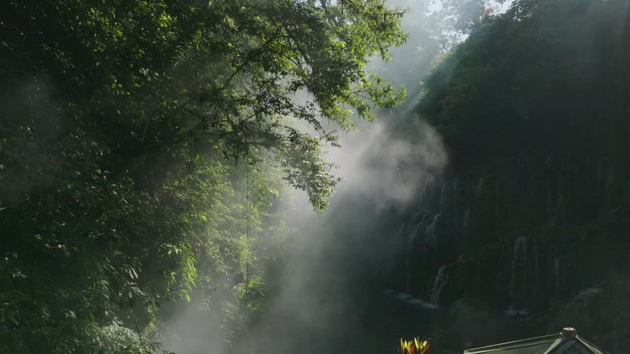 航拍:无人机拍摄的瀑布在岩石上流动在大雾天气-巴厘岛，印度尼西亚视频素材