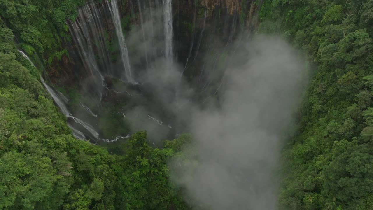 空中降落的云在著名的瀑布上的岩层在绿色森林-爪哇，印度尼西亚视频素材