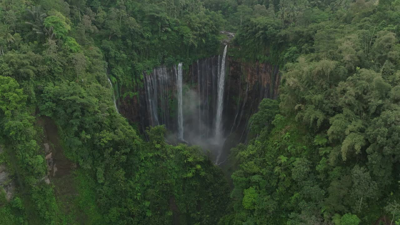 空中向前拍摄著名的Coban Sewu瀑布岩石与绿色森林-爪哇，印度尼西亚视频素材