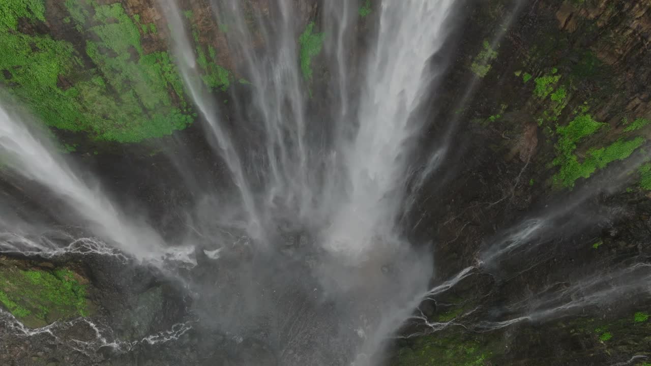 空中向上拍摄的Coban Sewu瀑布在岩石上流动-爪哇，印度尼西亚视频素材