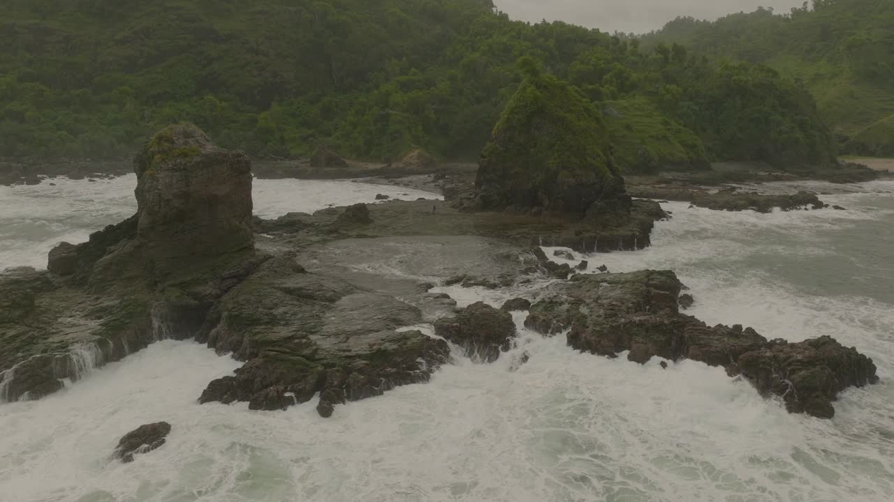 在有图案的波浪海中的岩层的平移镜头-爪哇，印度尼西亚视频素材