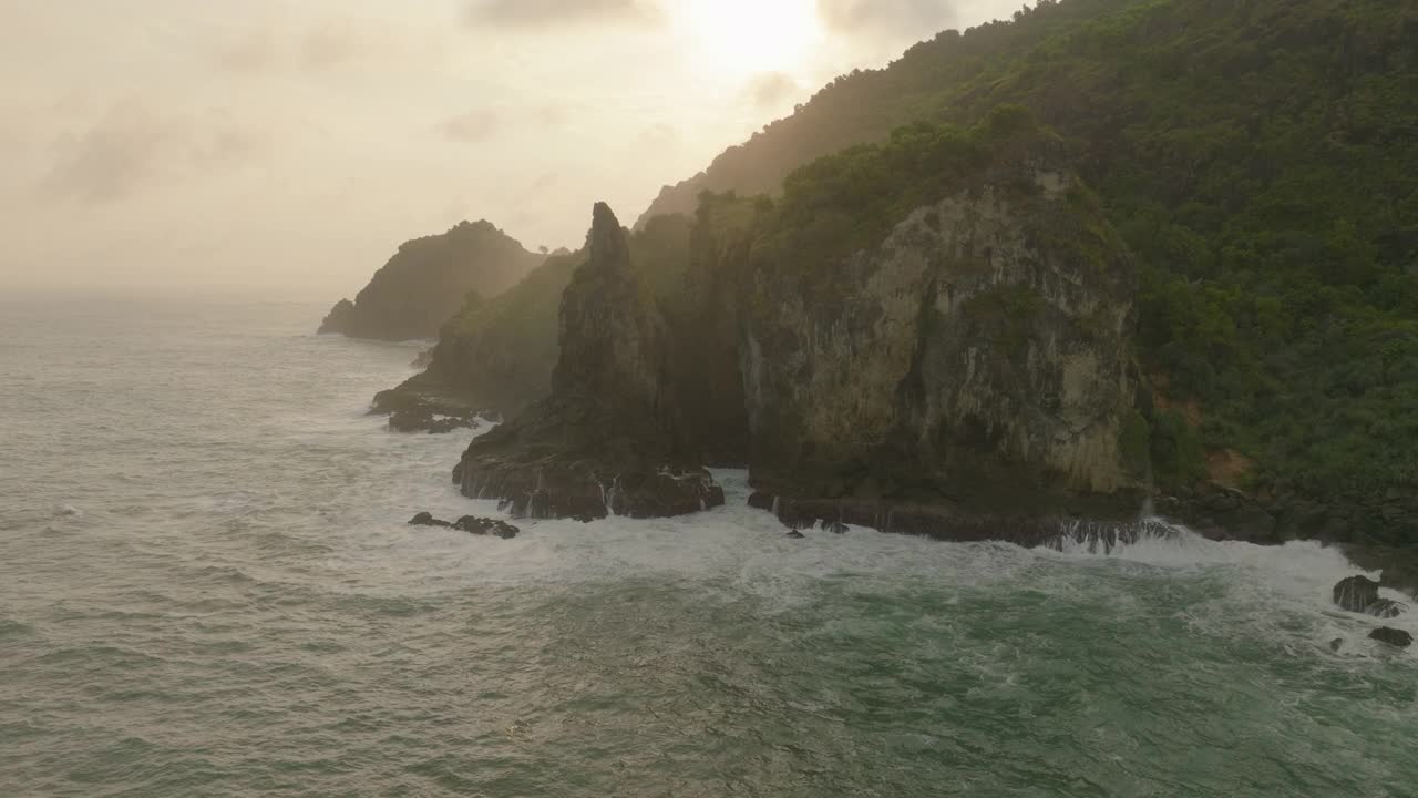 空中田园诗般的自然岩层，无人机在日落期间飞越海面-爪哇，印度尼西亚视频素材