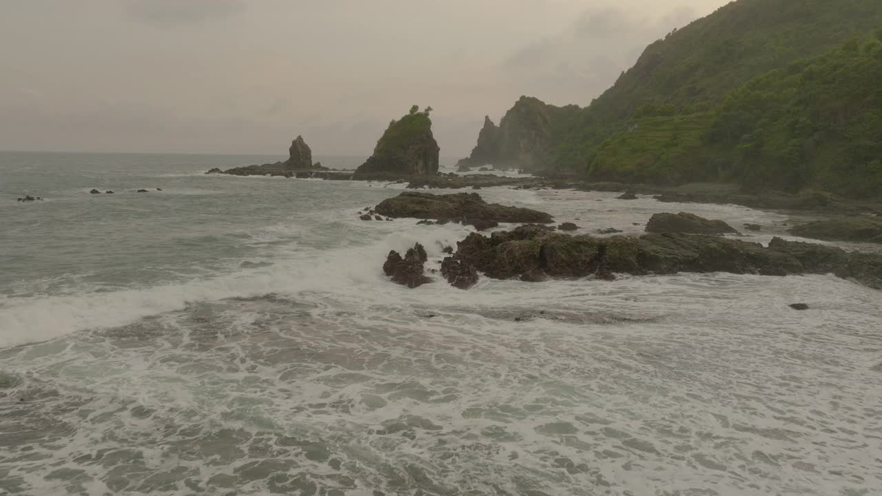 空中上升的美丽景色的山脉和波浪的大海，在日落时无人机向前飞行-爪哇，印度尼西亚视频素材