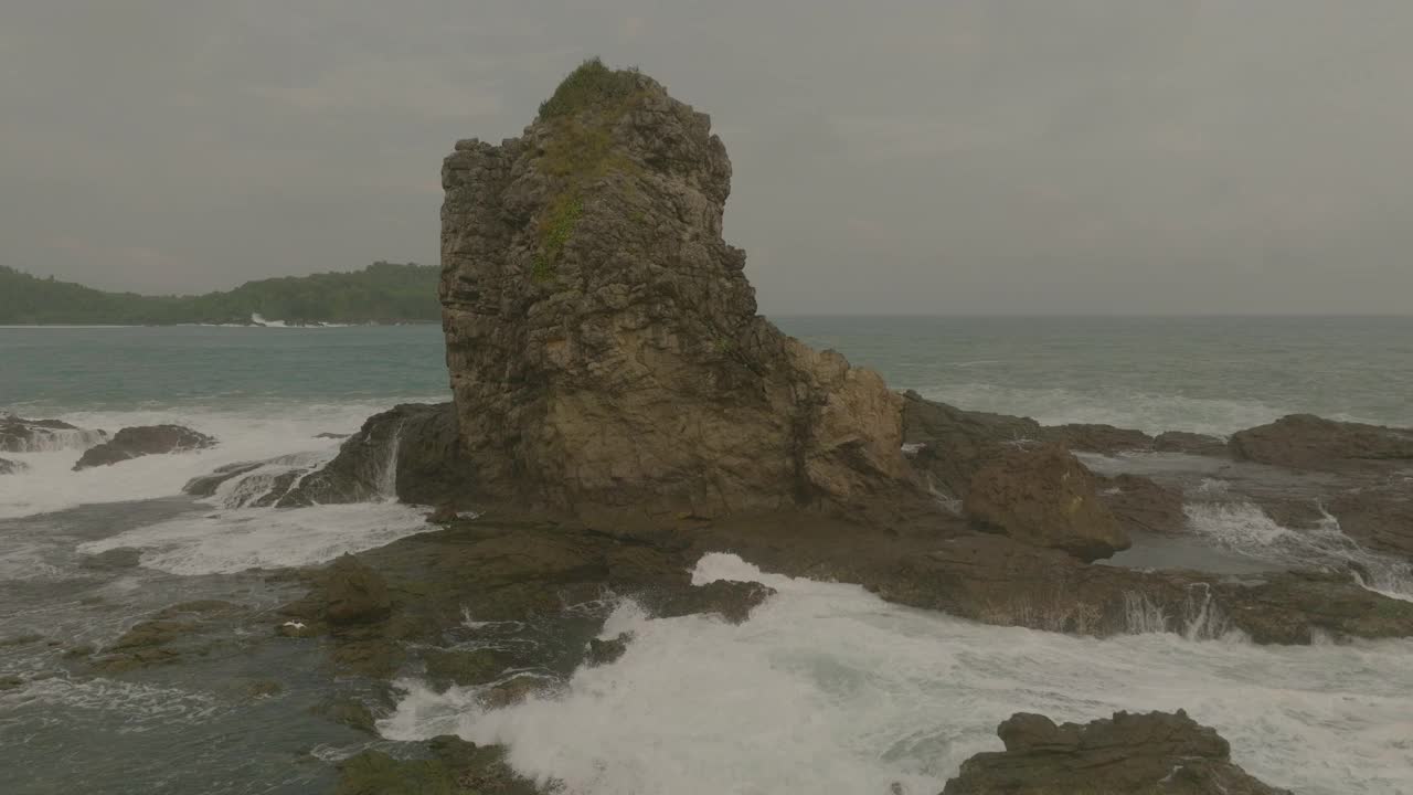 空中美丽的岩石对云的看法，无人机在波浪海洋上向后飞行-爪哇，印度尼西亚视频素材