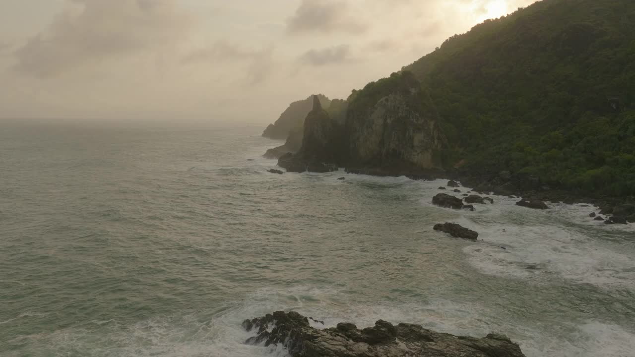 云层下的山的空中美景，日落时无人机在海洋上空向前飞行-爪哇，印度尼西亚视频素材