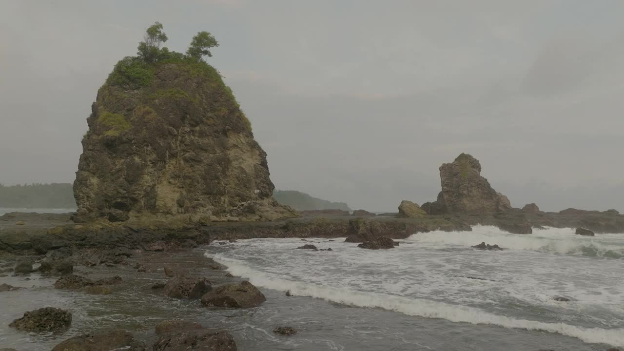 在多云的天空的海上岩石形成的空中向后风景视图-爪哇，印度尼西亚视频素材