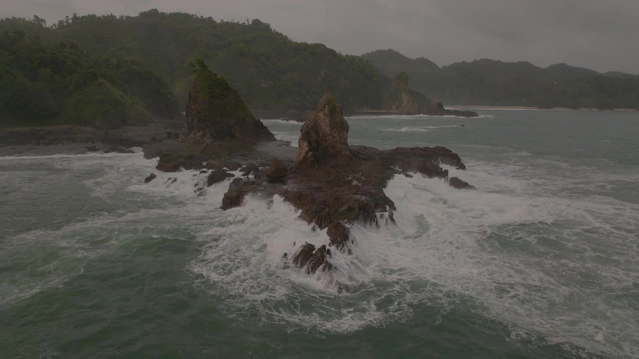 空中封锁风景的海浪飞溅在岩石上日落-爪哇，印度尼西亚视频素材