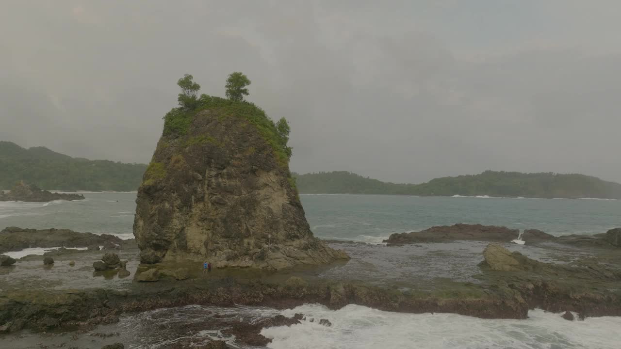 人们在度假期间探索海上岩层的空中平移镜头-印度尼西亚爪哇视频素材