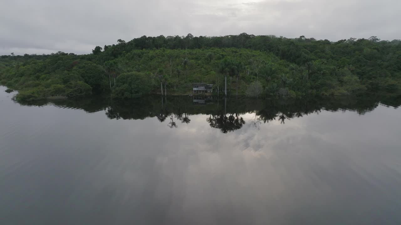 航拍的小屋在宁静的亚马逊雨林，无人机飞越河流-玛瑙斯，巴西视频素材