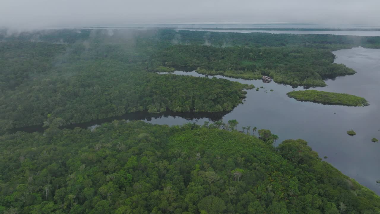 航拍的船屋停泊在宁静的河流，无人机飞行在亚马逊丛林-玛瑙斯，巴西视频素材