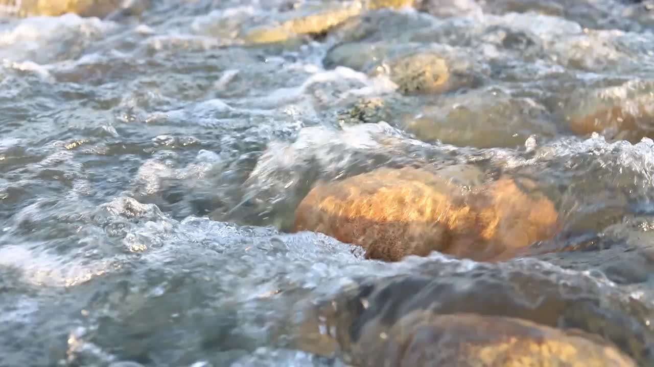 河水流过，绕过石头。视频素材