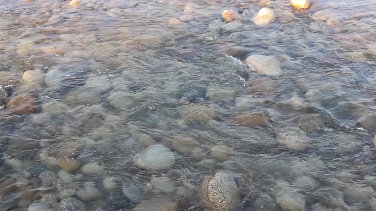 晶莹剔透，清澈剔透，用清澈的卵石拍打着河水视频素材