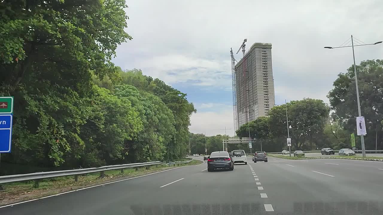 在高速公路上行驶，车辆，汽车，树木，建筑物，云，山视频素材