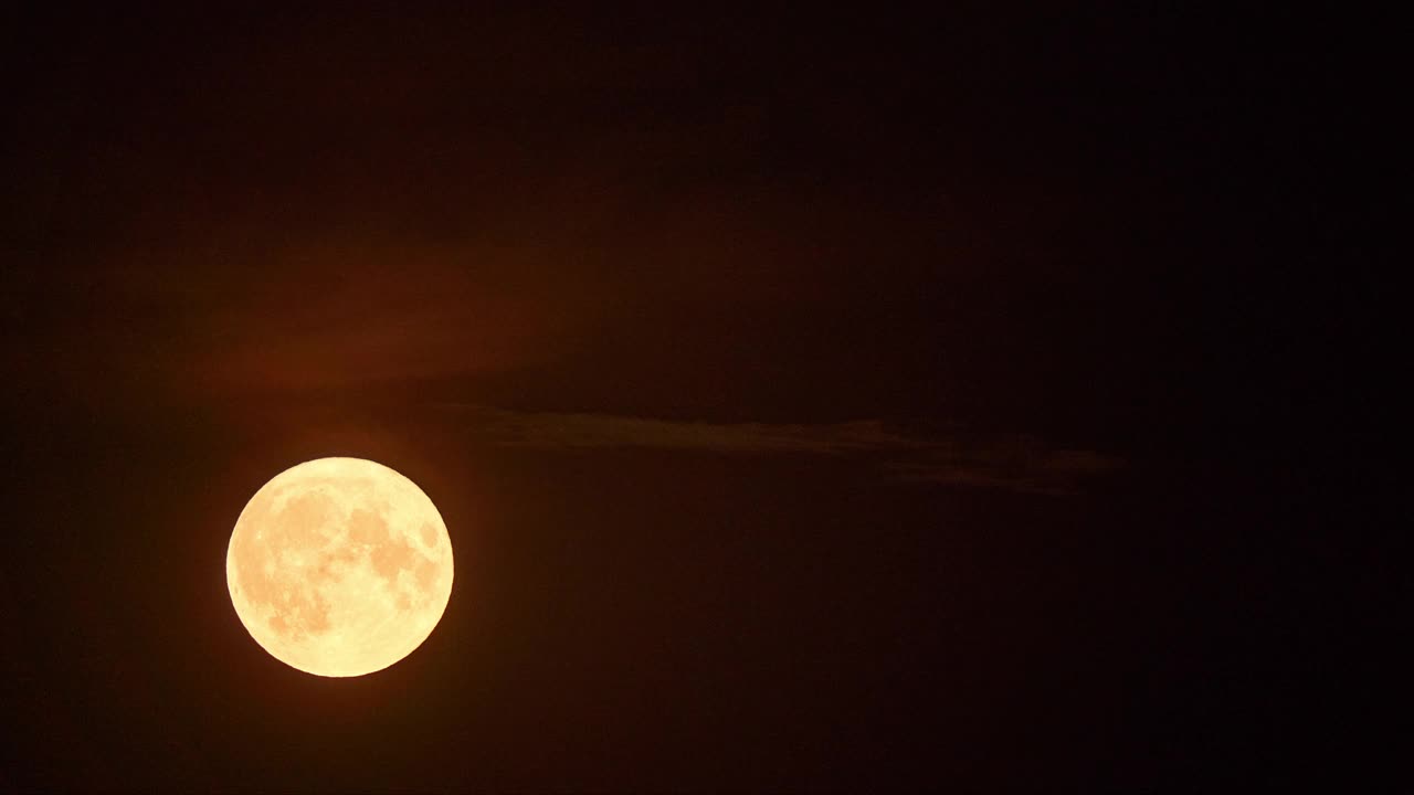 夜晚云后诡异满月的时间流逝。视频素材