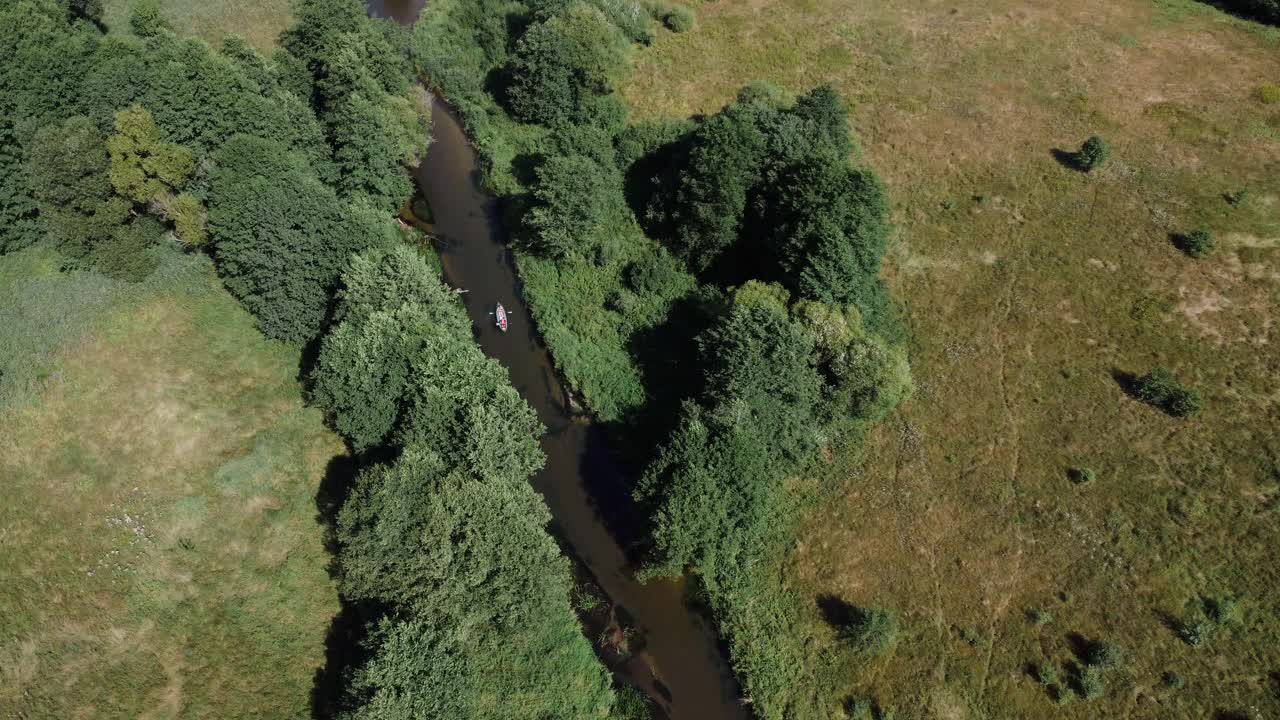 皮划艇生态旅游皮划艇在田野和绿树之间的河上旅行视频素材