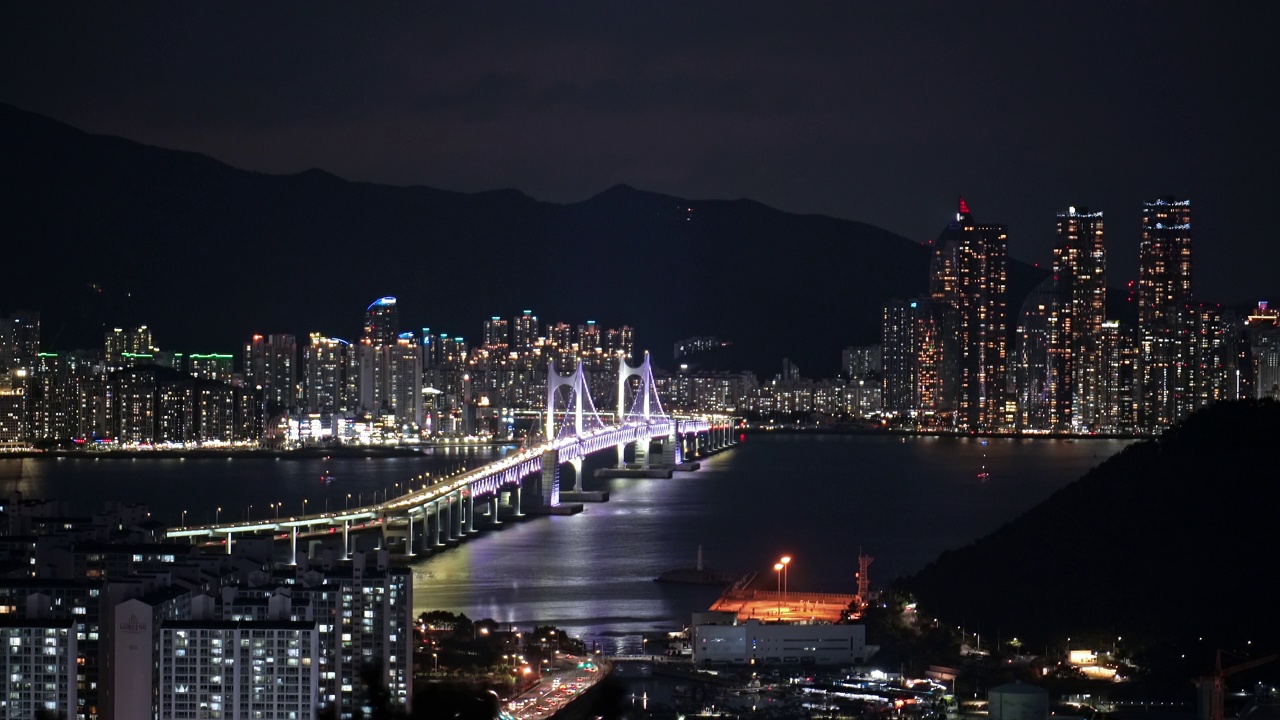 韩国釜山南区水永区海云台区夜间广安达桥附近的海洋城和市中心的摩天大楼视频素材