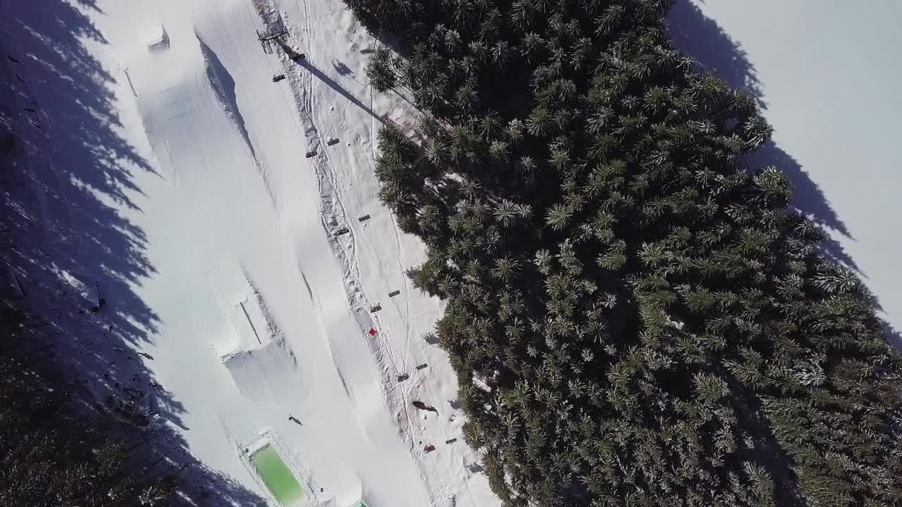 无人机直接从上空拍摄了雪场滑雪道的视频。乌克兰西部喀尔巴阡山脉的冬季运动公园。活跃旅游的热门旅游目的地视频素材