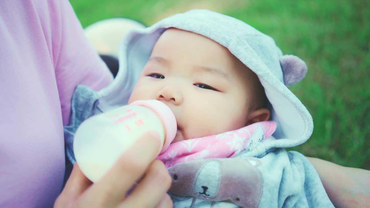 近距离的可爱的男婴蹒跚学步喝婴儿牛奶从瓶子视频素材