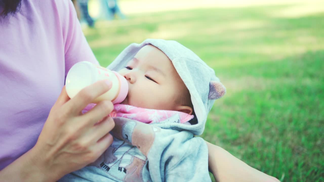 近距离的可爱的男婴蹒跚学步喝婴儿牛奶从瓶子视频素材