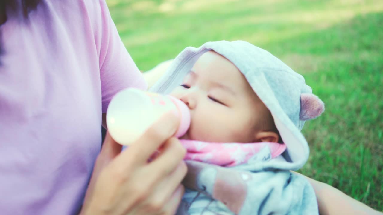 近距离的可爱的男婴蹒跚学步喝婴儿牛奶从瓶子视频素材