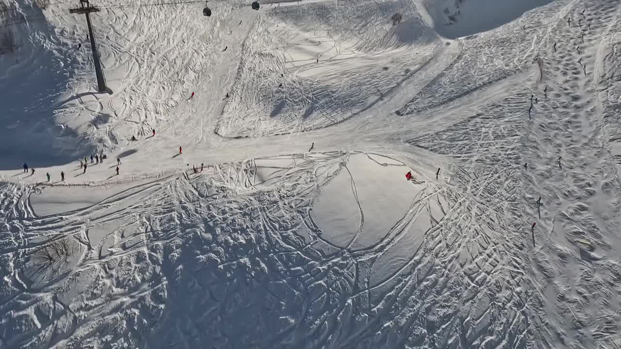 滑雪场的人骑在斜坡上滑雪索道山上阳光明媚的冬日视频素材