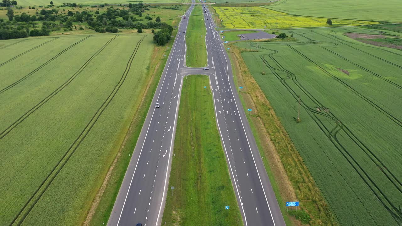 沥青公路穿过绿色的夏日田野。鸟瞰图视频素材