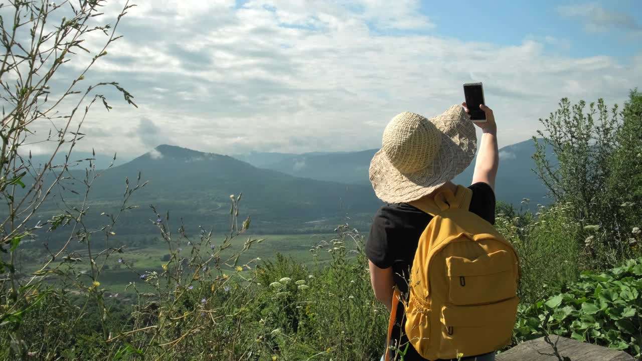 女性旅行者独自一人在山上旅行时用手机自拍视频素材