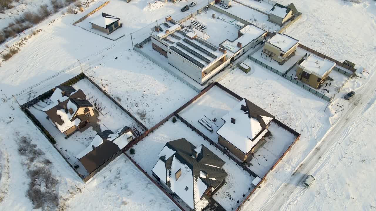 在寒冷的冬天，郊区郊区的私人住宅屋顶被雪覆盖的鸟瞰图视频素材