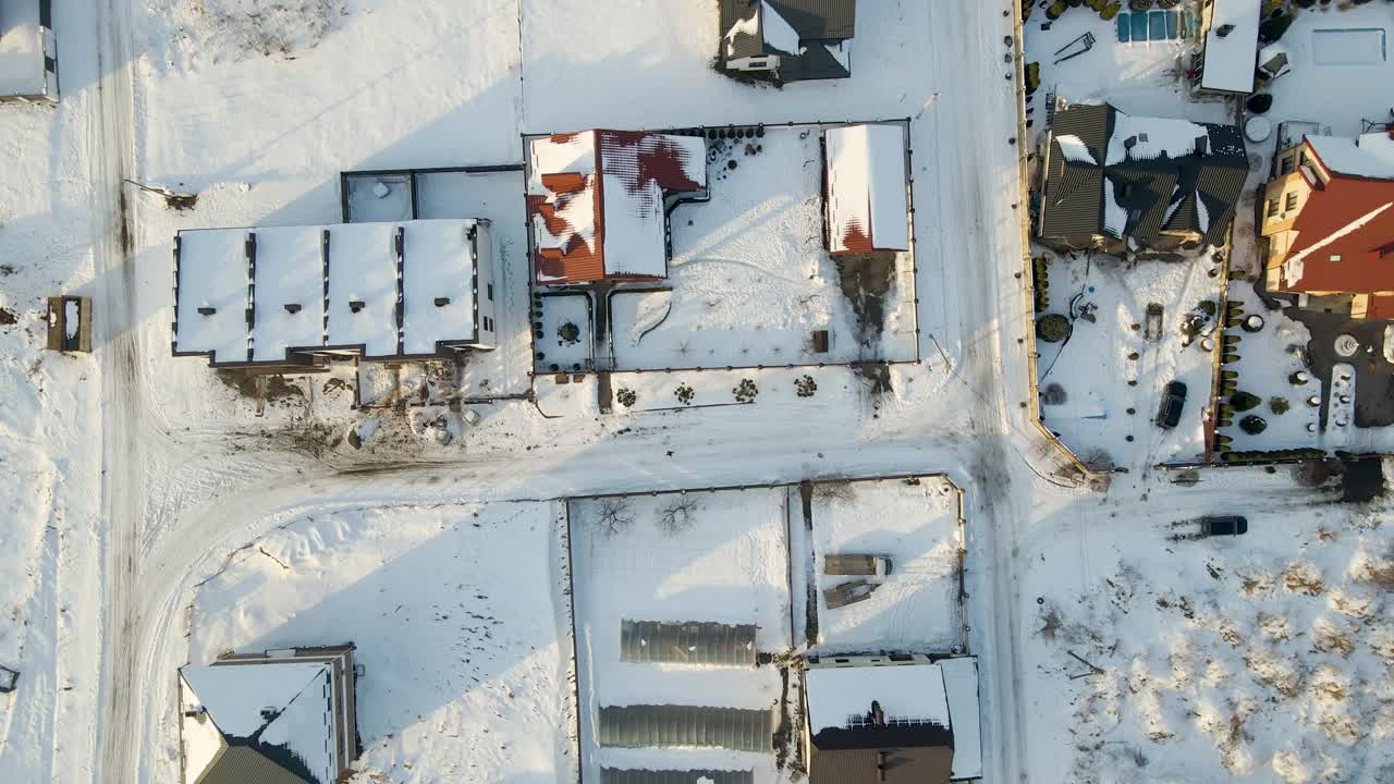 在寒冷的冬天，郊区郊区的私人住宅屋顶被雪覆盖的鸟瞰图视频素材