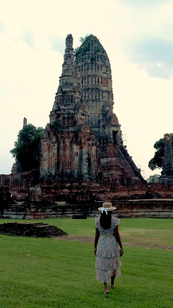 亚洲妇女手里拿着旅游地图，看着泰国大城府的废墟和宝塔视频素材