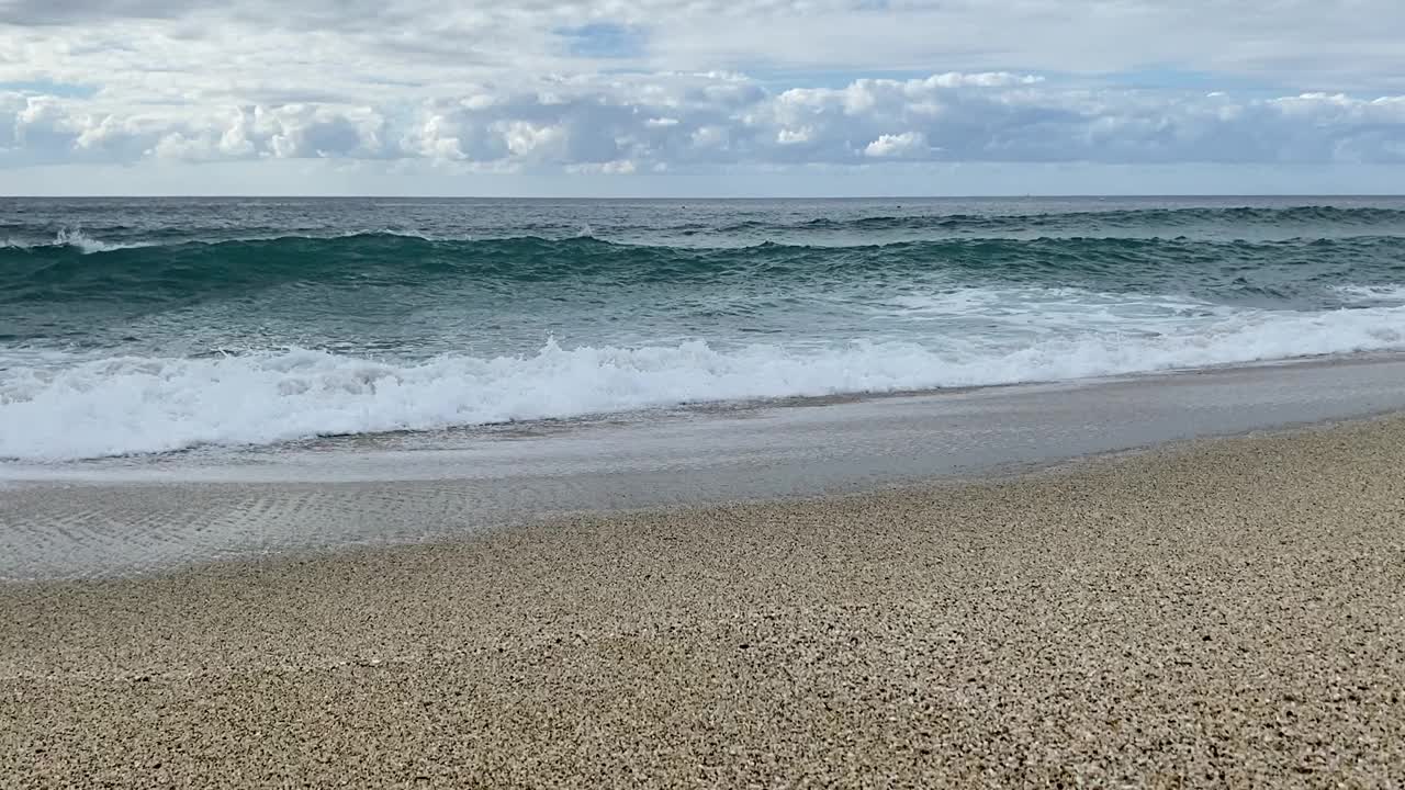 在阴天，海浪在沙滩上翻滚视频下载