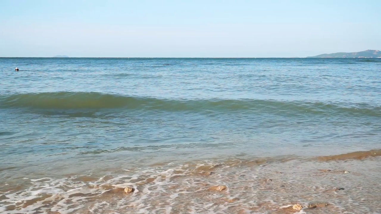 海浪冲击着蓝天的沙滩视频素材