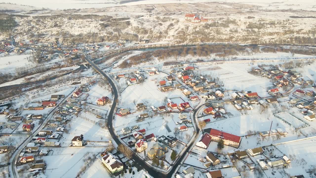 冬季郊区农村城镇地区，汽车行驶在积雪覆盖的住宅之间的街道上视频素材