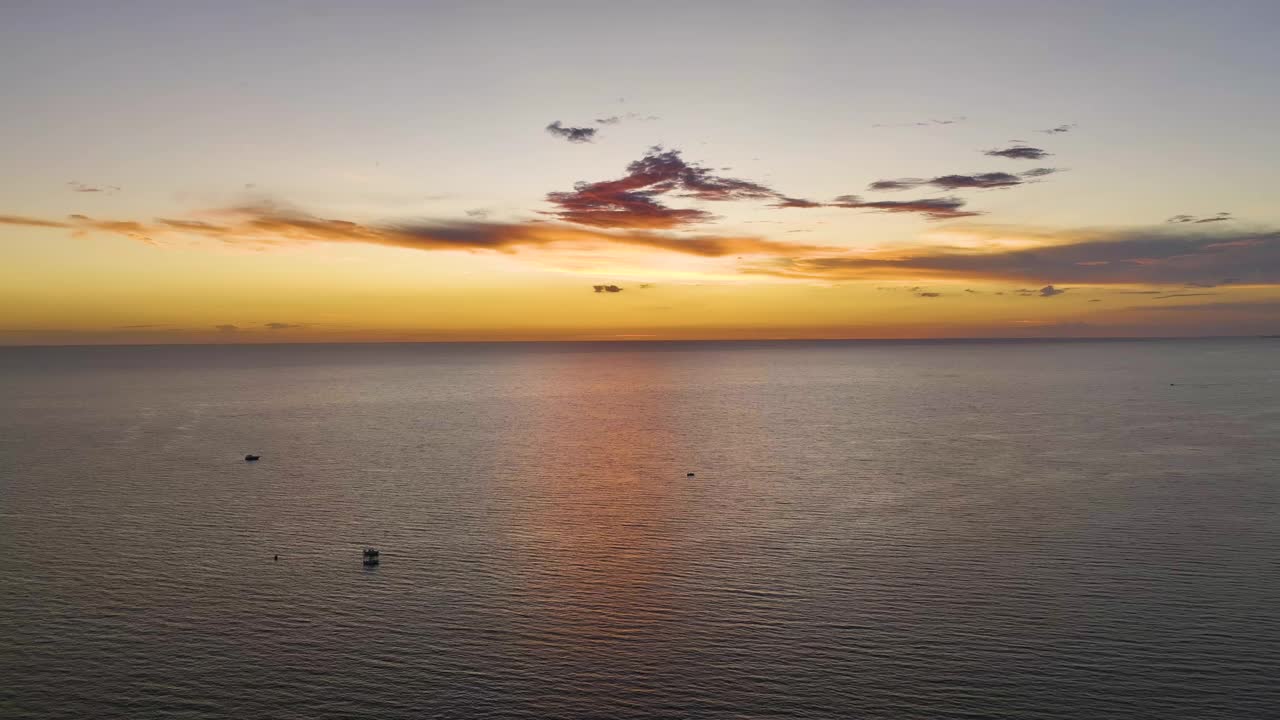 日落时漂浮在海浪上的白色游艇的鸟瞰图。海面摩托艇娱乐视频素材