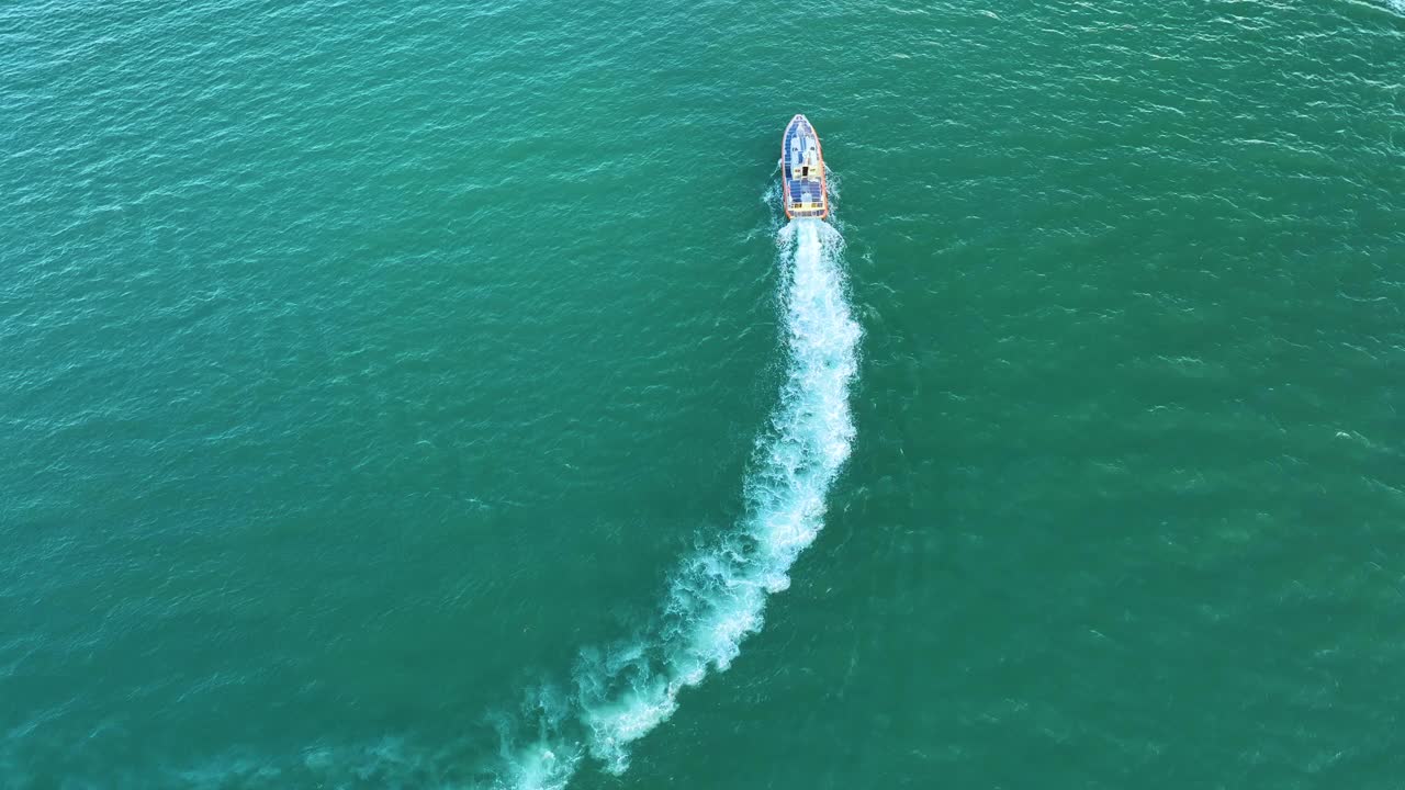 鸟瞰白色游艇游泳在海浪与波纹表面。在海洋上运动的摩托艇视频素材