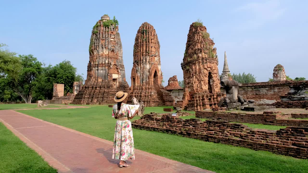 亚洲妇女手里拿着旅游地图，看着泰国大城府的废墟和宝塔视频素材