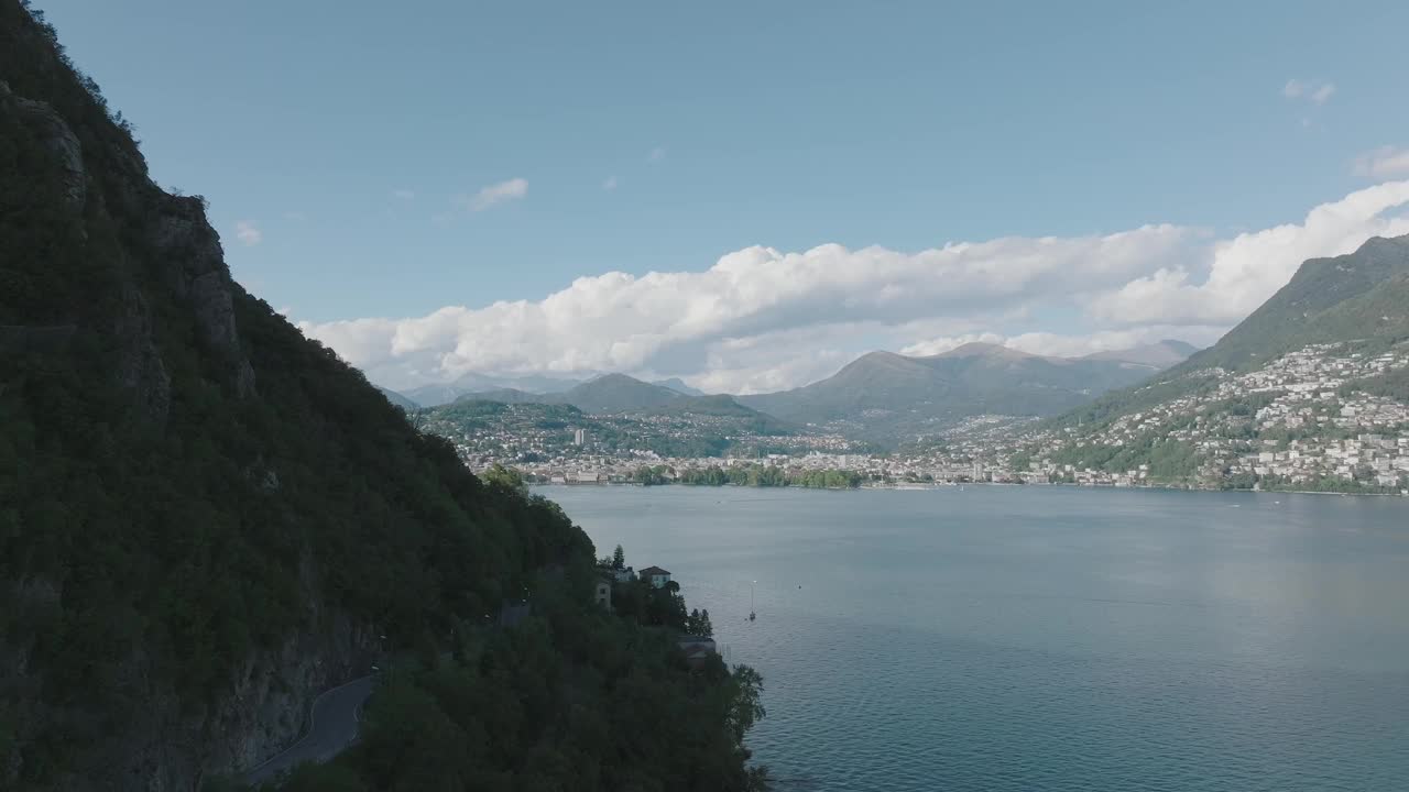 在一个晴朗的夏日，飞越群山环绕的高山湖泊视频素材