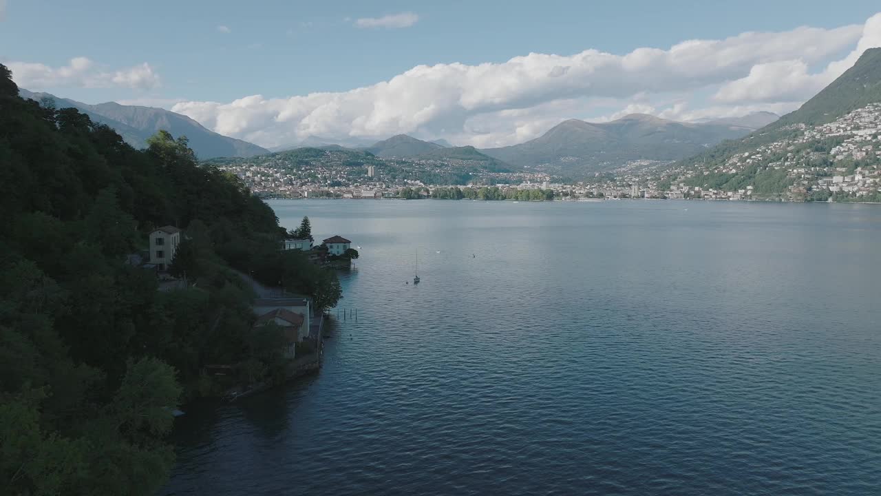 在一个晴朗的夏日，飞越群山环绕的高山湖泊视频素材