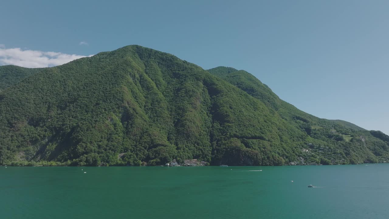 在一个晴朗的夏日，飞越群山环绕的高山湖泊视频素材