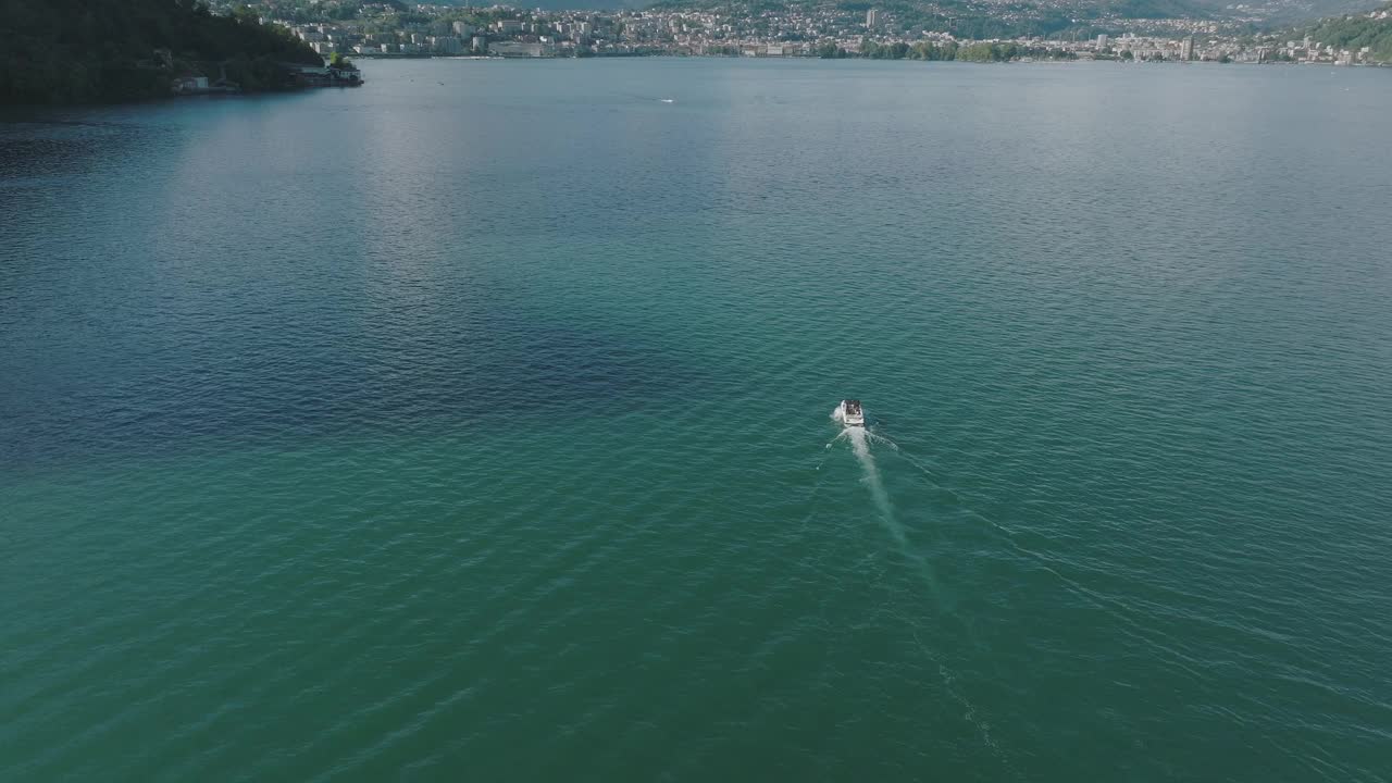 夏日晴空万里，飞越群山环绕的湖泊，远处是卢加诺市视频素材