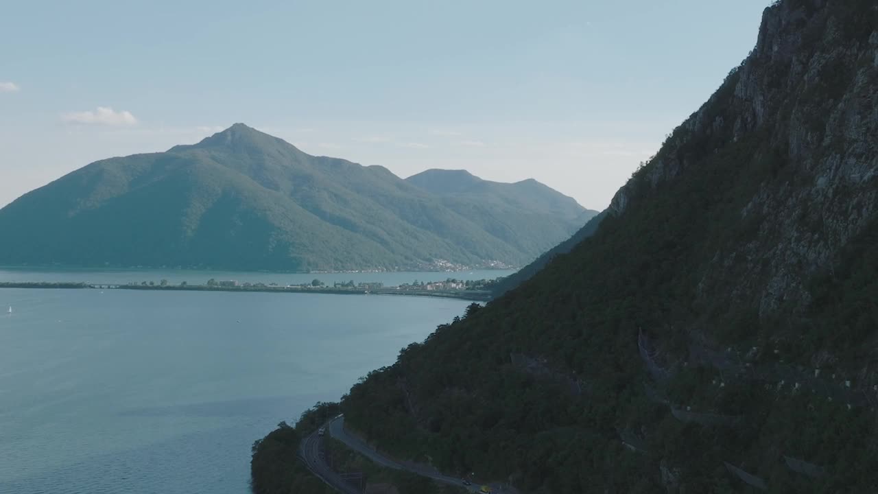 在一个晴朗的夏日，飞越群山环绕的高山湖泊视频素材