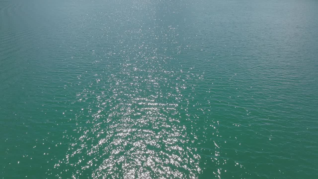 在一个晴朗的夏日，飞越群山环绕的高山湖泊视频素材