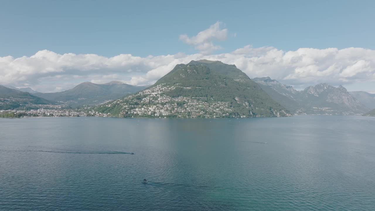 夏日晴空万里，飞越群山环绕的湖泊，远处是卢加诺市视频素材