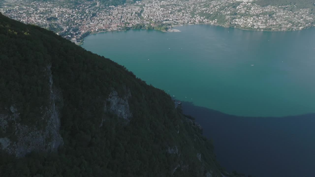 夏日晴空万里，飞越群山环绕的湖泊，远处是卢加诺市视频素材