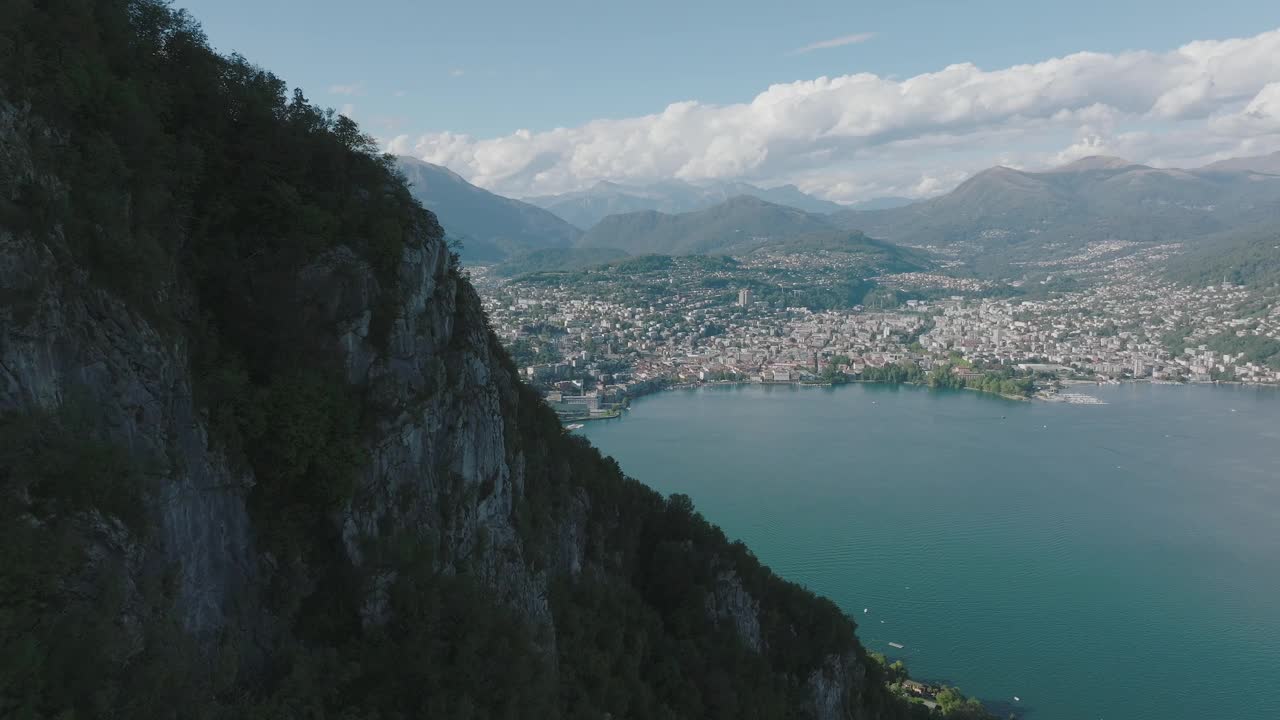 夏日晴空万里，飞越群山环绕的湖泊，远处是卢加诺市视频素材